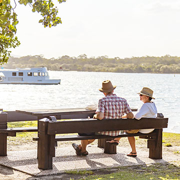 Things To Do In Noosaville Couple Sat On Bench By The Noosa River